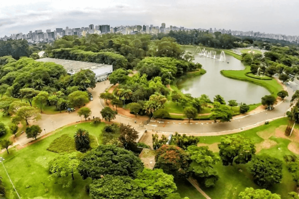 鳥瞰圖顯示了伊比拉普埃拉公園的茂密綠地和湖泊，背景是聖保羅的城市天際線。