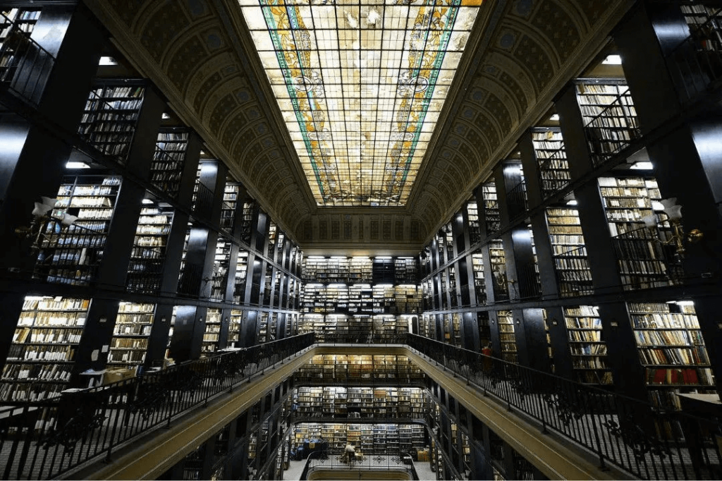 里約熱內盧國家歷史博物館內部，寬敞的圖書館配有高聳的書架和壯麗的彩色玻璃天花板。